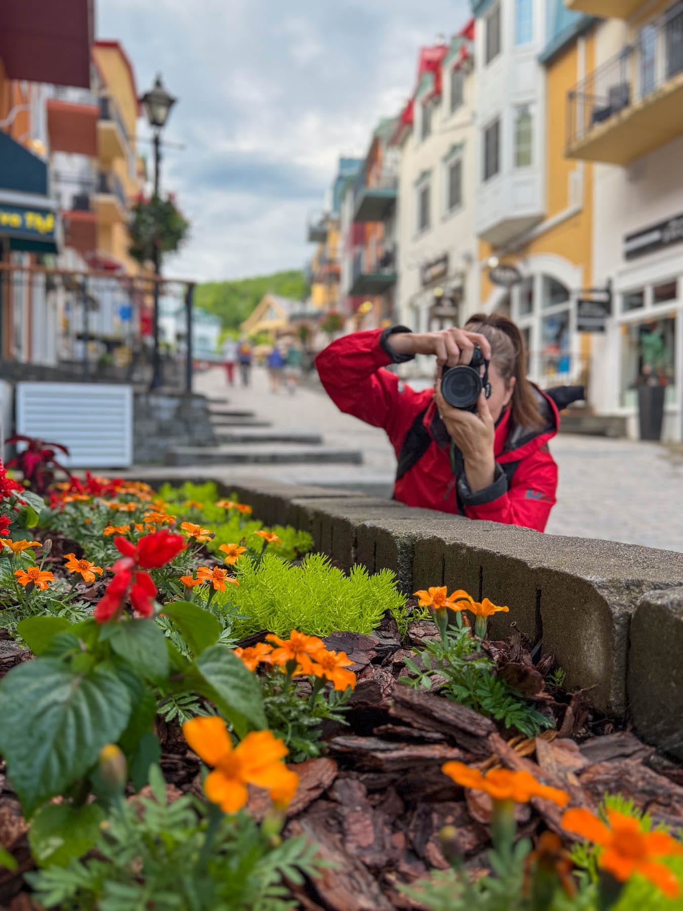 Jami Savage in red jacket, colourful village street, Mont Tremblant, Quebec