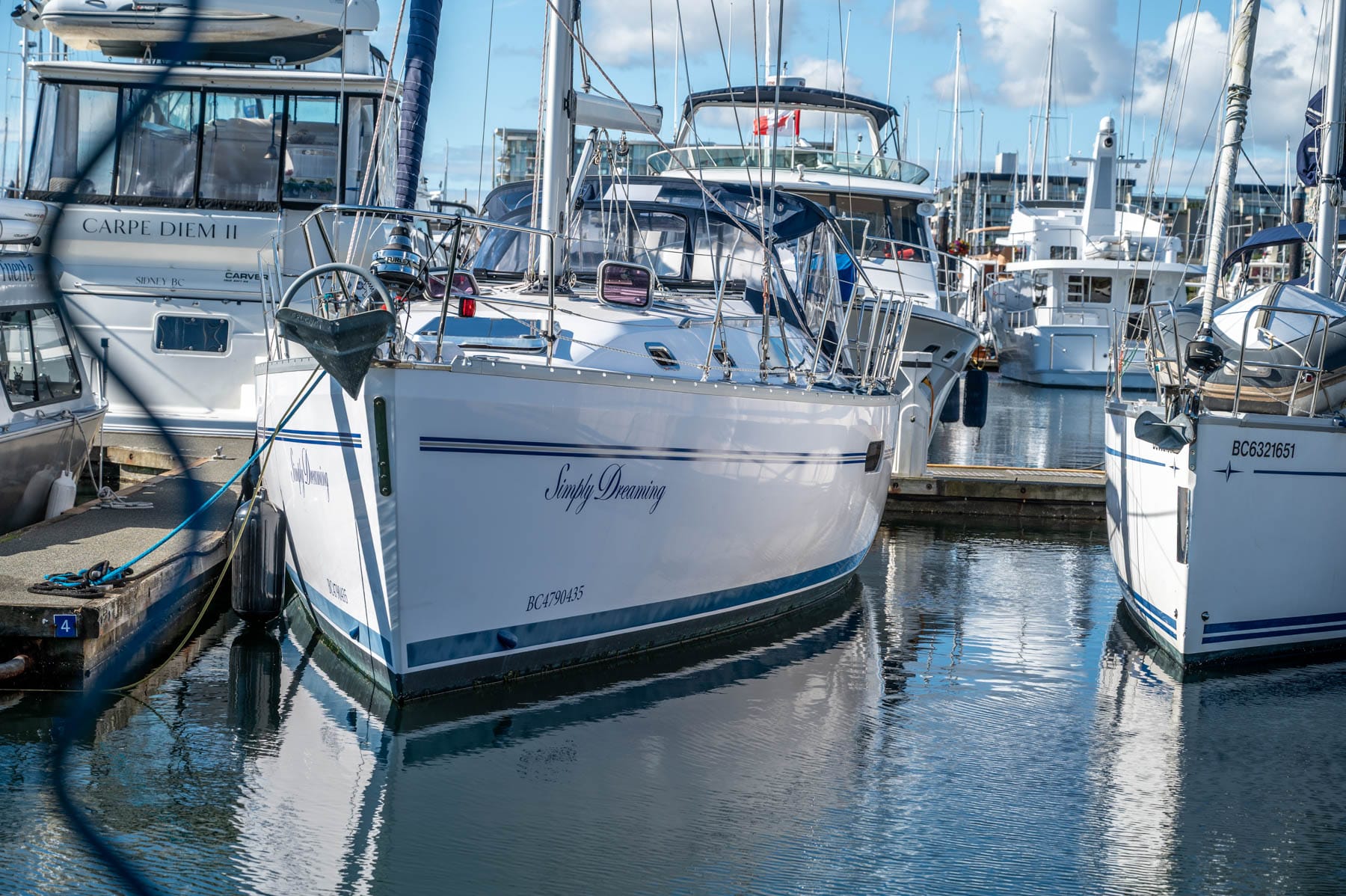 Sailing BC’s Gulf Islands Family Trip- white sailboat "Simply Dreaming" docked in a marina with blue water and sky