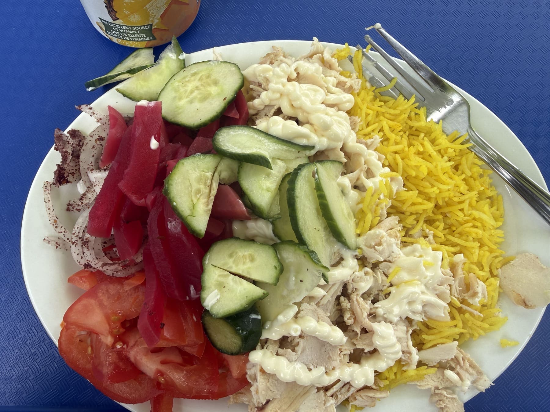 rotisserie-style chicken shaved off the spit, rice, cucumber, and vegetables