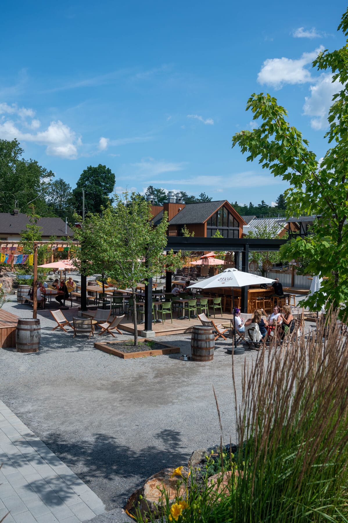 An outdoor public plaza and patio area with a bar, seating, and wooden buildings - Square Old Chelsea located in Chelsea, Quebec, Canada
