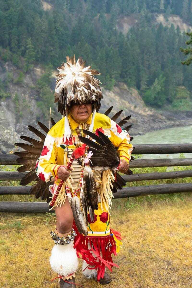 First Nations individual wearing traditional regalia, participating in a cultural dance or celebration in British Columbia, Canada